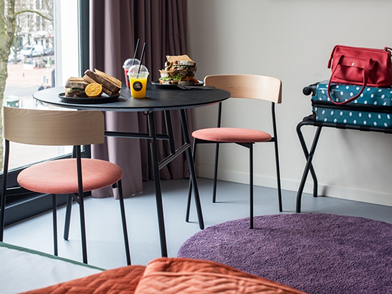 Table in a room with breakfast on it and suitcases next to it in Hotel Unplugged